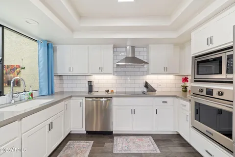 a kitchen with stainless steel appliances a sink stove and cabinets