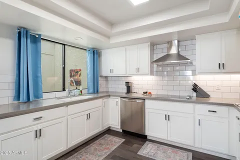 a kitchen with granite countertop white cabinets white appliances and a sink
