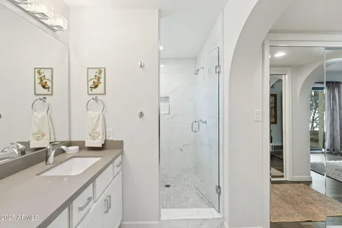 a bathroom with a double vanity sink mirror and shower