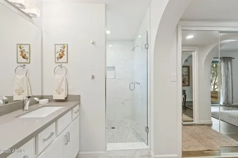 a bathroom with a granite countertop sink mirror and a shower