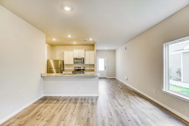 a kitchen with stainless steel appliances granite countertop a sink refrigerator and cabinets