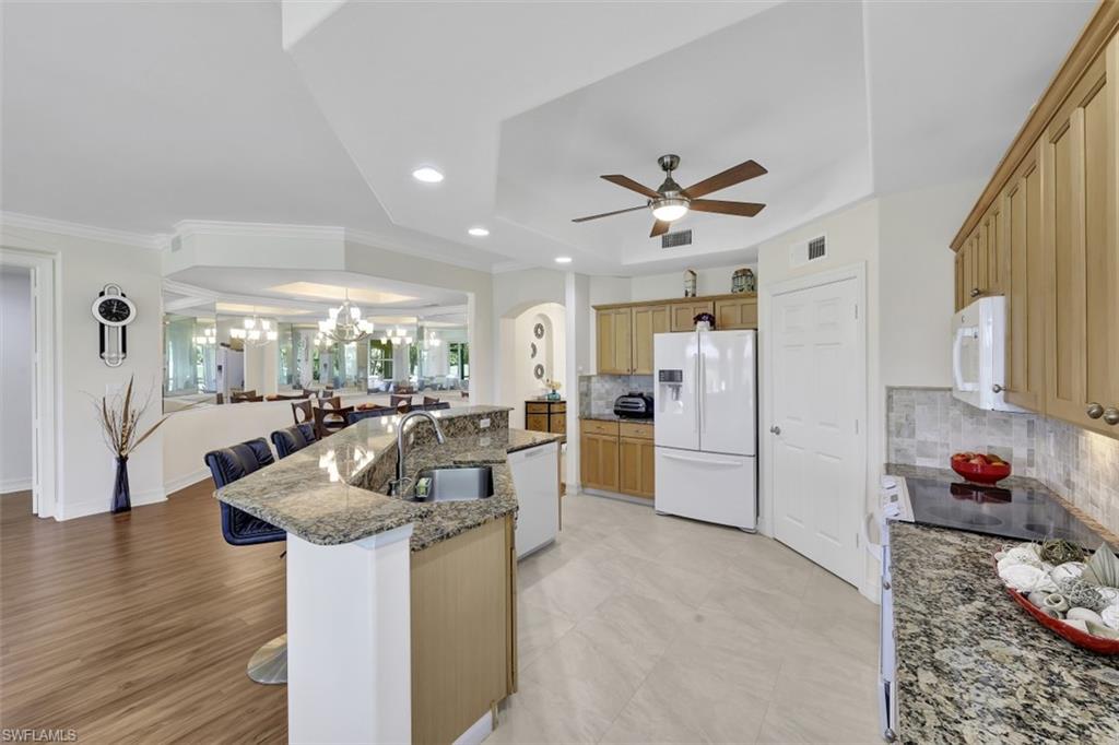 1276 Rialto Way, Unit 101 Naples, FL 34114 - Photo 11 of 37 a living room with furniture a flat screen tv and a table