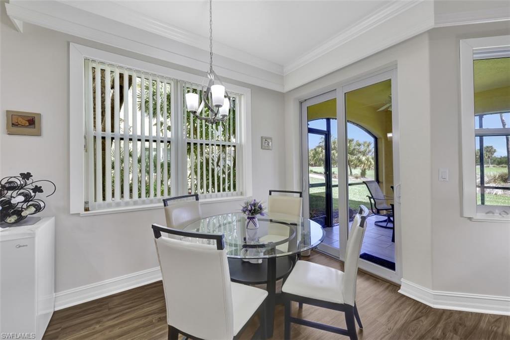 1276 Rialto Way, Unit 101 Naples, FL 34114 - Photo 12 of 37 a view of a dining room with furniture wooden floor and a chandelier