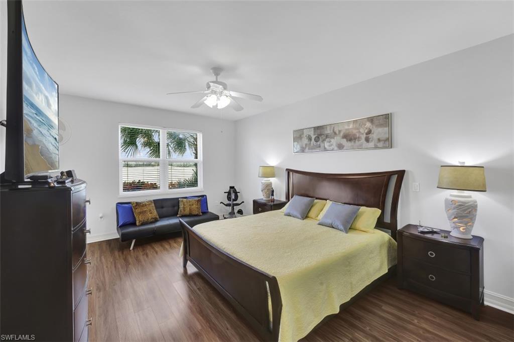 1276 Rialto Way, Unit 101 Naples, FL 34114 - Photo 14 of 37 a bedroom with a bed and a flat tv screen on the dresser