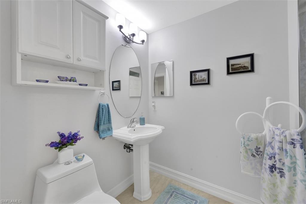 1276 Rialto Way, Unit 101 Naples, FL 34114 - Photo 17 of 37 a bathroom with a sink mirror and toilet