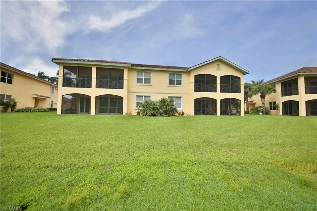 1276 Rialto Way, Unit 101 Naples, FL 34114 - Photo 25 of 37 a front view of a house with a yard