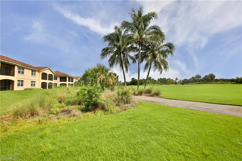 1276 Rialto Way, Unit 101 Naples, FL 34114 - Photo 27 of 37 a view of a house with a yard