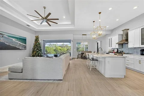 a living room with furniture kitchen view and a chandelier