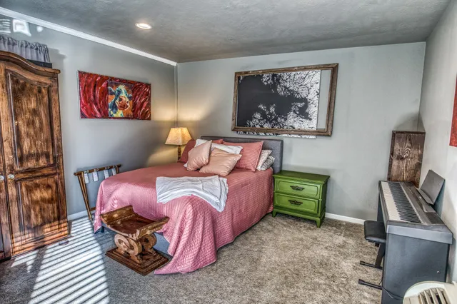 a bedroom with a bed and a painting on the wall
