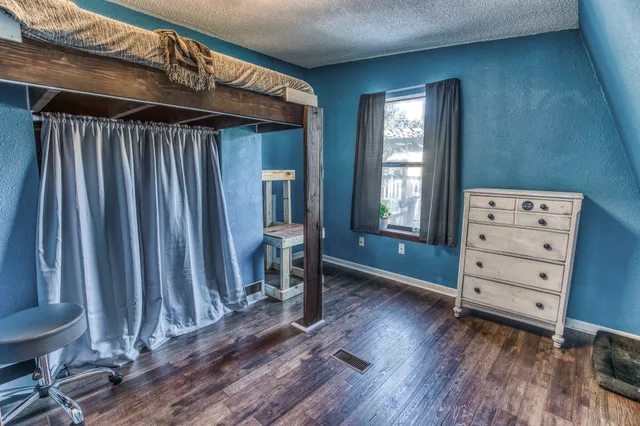 a view of a bedroom with furniture and window