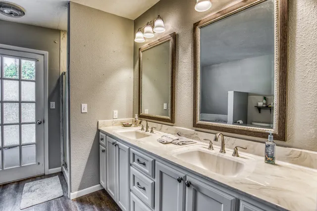 a bathroom with double vanity and a mirror