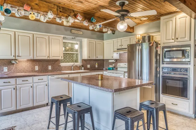 a kitchen with stainless steel appliances granite countertop a sink refrigerator and cabinets