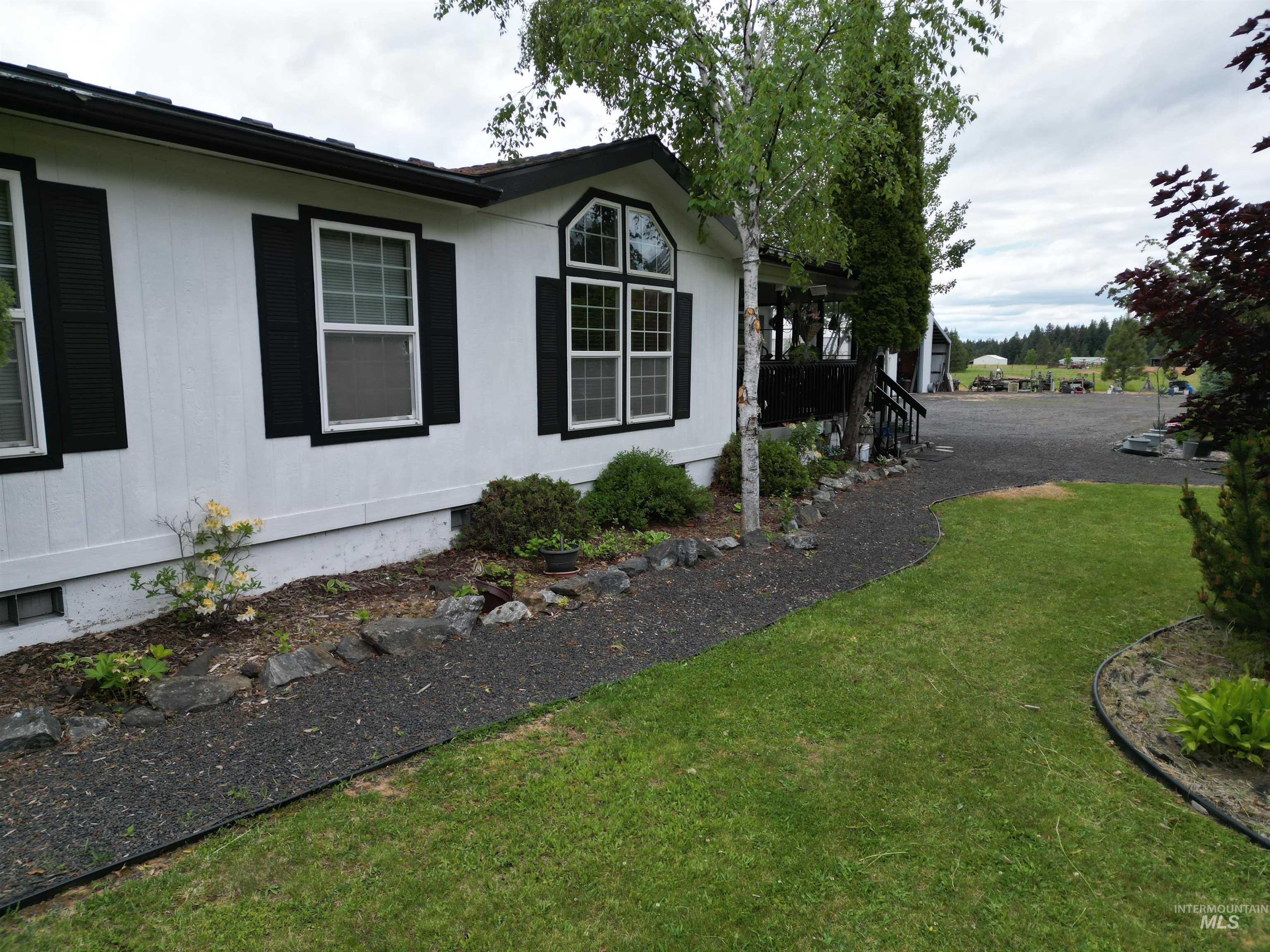 254 Lackey Road Weippe, ID 83553 - Photo 2 of 38 White exterior siding with black window shutters and trim