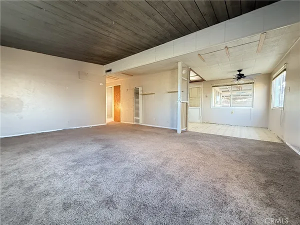 a view of empty room with a kitchen