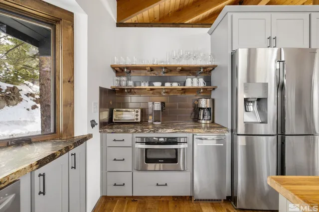 a kitchen with granite countertop a stove and a refrigerator