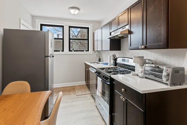 a kitchen with stainless steel appliances granite countertop a stove a sink and a refrigerator