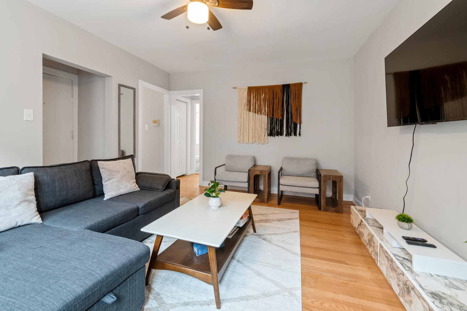 6439 North Hamilton Avenue, Unit 2C Chicago, IL 60645 - Photo 5 of 10 a living room with furniture and a flat screen tv