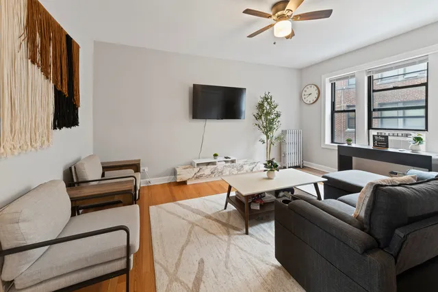 a living room with furniture a flat screen tv and a window
