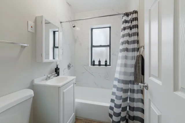 a bathroom with a sink a toilet and shower