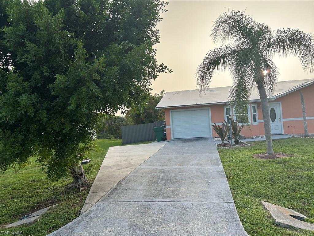 2049 50th Street Southwest Naples, FL 34116 - Photo 3 of 7 front view of a house with a yard and potted plants