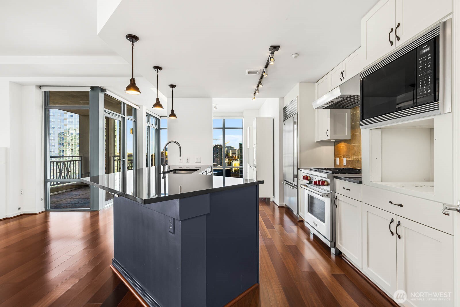 819 Virginia Street, Unit 3303 Seattle, WA 98101 - Photo 4 of 29 a kitchen with stainless steel appliances granite countertop a refrigerator a stove top oven a sink dishwasher and white cabinets with wooden floor