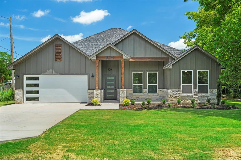 a front view of a house with a garden and yard