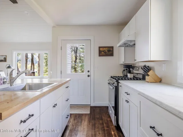 a kitchen with granite countertop a sink a stove and cabinets