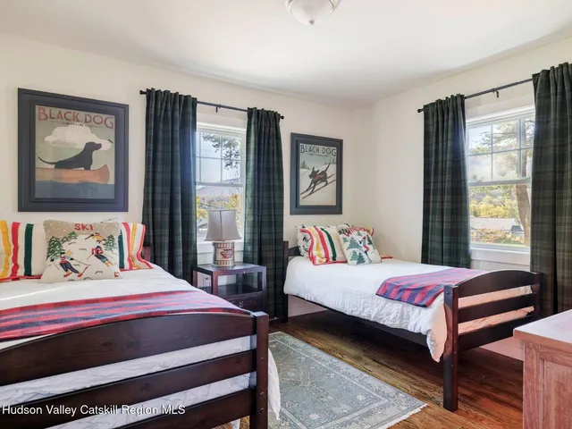 a bedroom with a bed wooden floor and window