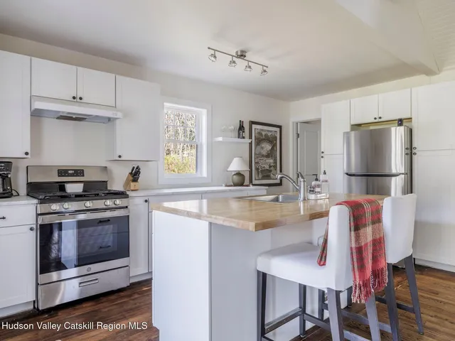 a kitchen with kitchen island a stove a refrigerator and a sink