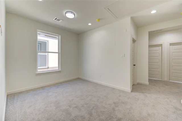 an empty room with windows and closet