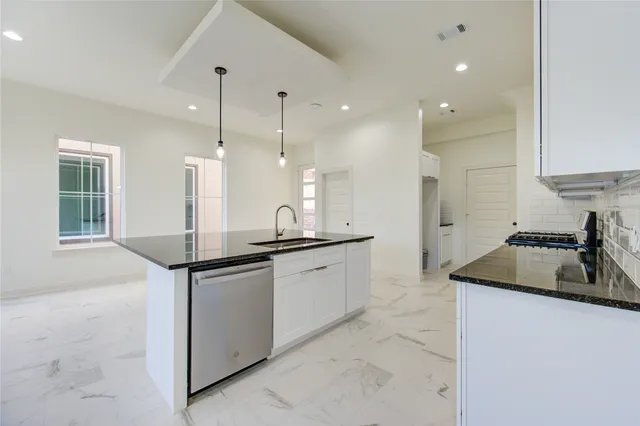a kitchen with stainless steel appliances granite countertop a sink and a refrigerator