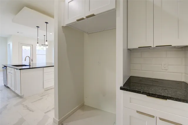 a kitchen with white cabinets and stainless steel appliances