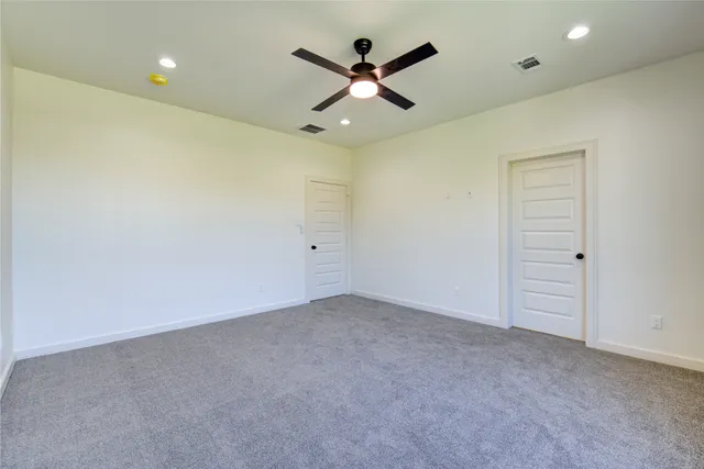 an empty room with closet and fan