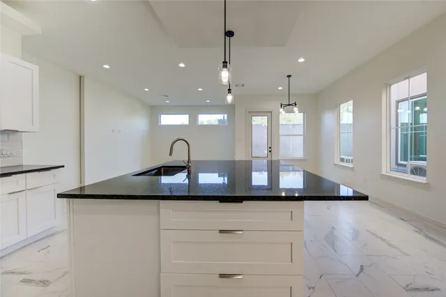 a kitchen with kitchen island a sink stainless steel appliances and cabinets