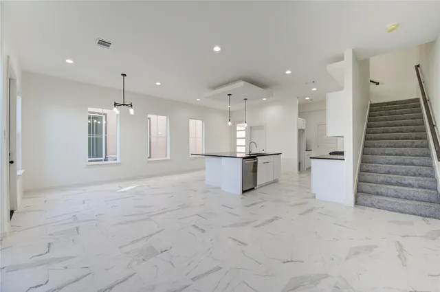 a view of an empty room with kitchen appliances and a window