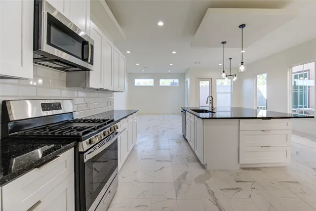 a kitchen with stainless steel appliances granite countertop a stove and a microwave