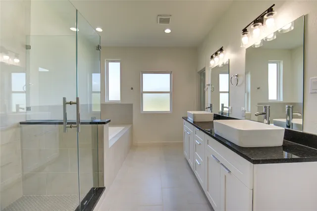 a bathroom with a granite countertop sink a large mirror and a shower