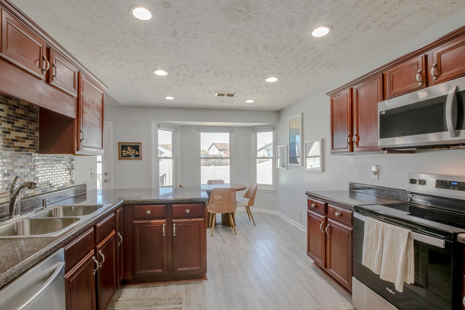 2112 Cason Trail Murfreesboro, TN 37128 - Photo 7 of 25 a kitchen with stainless steel appliances granite countertop a sink stove microwave and wooden floor