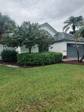 a front view of a house with a garden and plants