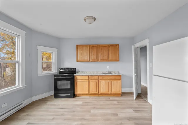 a view of a kitchen with stainless steel appliances granite countertop a stove and a refrigerator
