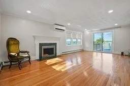 a view of empty room with wooden floor and fireplace