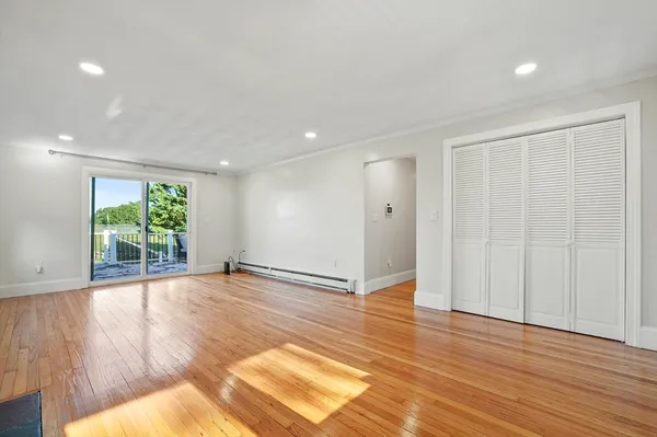an empty room with wooden floor and mirror
