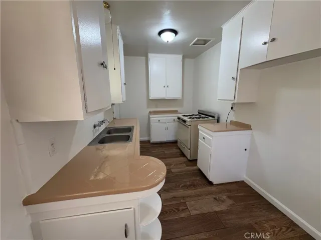 a room with a sink a stove and cabinets