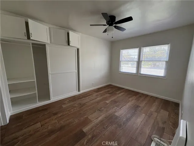 a view of empty room with wooden floor and window