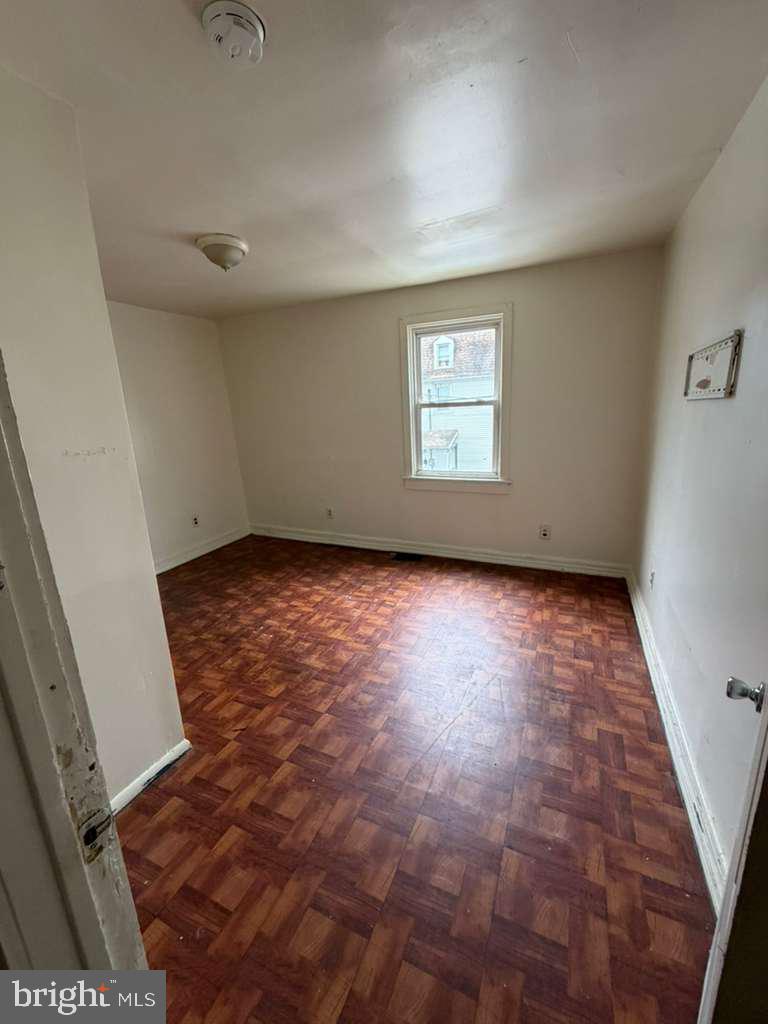 231 Broad Street, Unit B Beverly, NJ 08010 - Photo 4 of 9 an empty room with wooden floor and windows