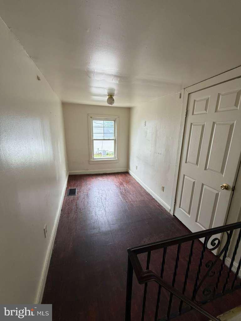 231 Broad Street, Unit B Beverly, NJ 08010 - Photo 5 of 9 a view of an empty room with wooden floor and windows