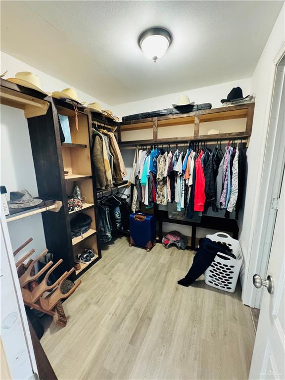 22417 Carrizales Road, Unit SERVICE Edinburg, TX 78542 - Photo 11 of 28 a view of walk in closet with clothes and shoes