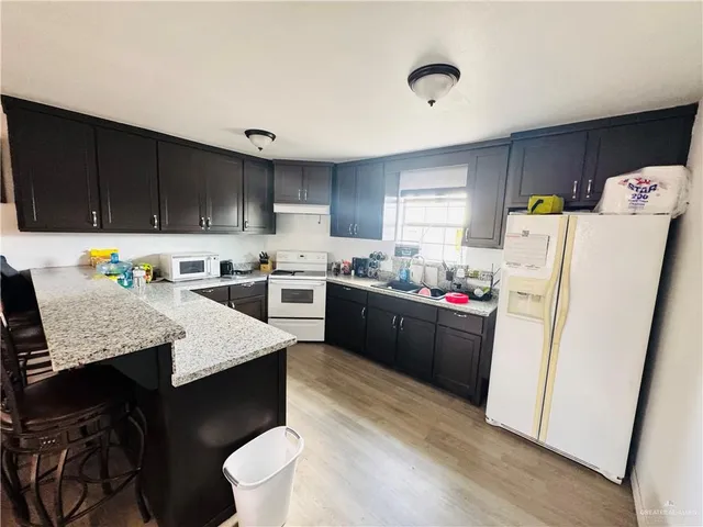 a kitchen with a refrigerator a stove a sink dishwasher and a refrigerator with wooden cabinets