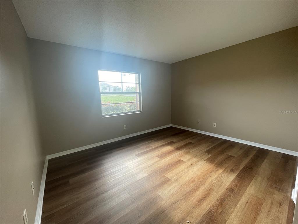 1350 South Alto Verde Terrace, Unit A Inverness, FL 34452 - Photo 5 of 14 an empty room with wooden floor and windows