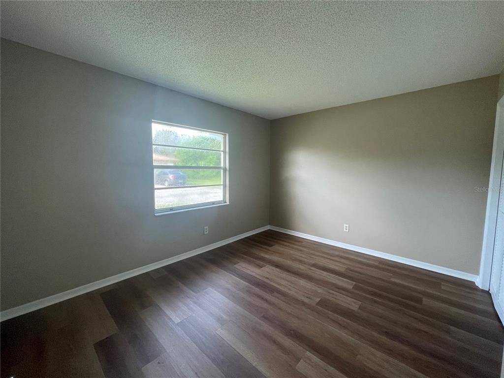 1350 South Alto Verde Terrace, Unit A Inverness, FL 34452 - Photo 7 of 14 an empty room with wooden floor and windows